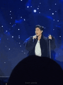 a man singing into a microphone with the name kwon unnie on the bottom left