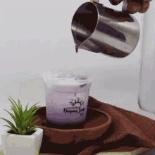 a person pouring liquid into a cup that says " daging kopi " on it