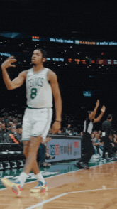 a basketball player with the number 8 on his jersey is walking on the court