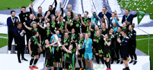 a group of soccer players are posing for a photo with a flag that says volkswagon on it