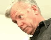 a close up of a man 's face with a black shirt