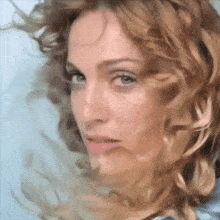 a close up of a woman 's face with long blonde hair