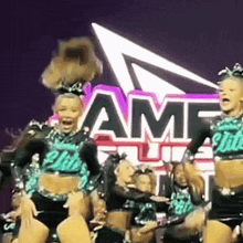 a group of cheerleaders are dancing in front of a sign that says amf