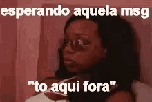 a woman with a black eye is laying on a bed with a caption that says `` esperando aquela msg '' .