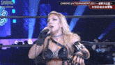 a woman is singing into a microphone on a stage .