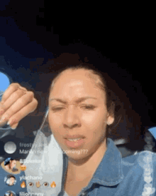 a woman in a denim jacket is sitting in a car with a mask on her face ..