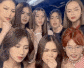 a group of young women are posing for a picture and one of them is covering her nose