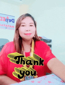 a woman wearing a red shirt that says " thank you "