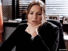 a woman is sitting at a desk with her hand on her chin and the word squadbot is on the bottom of the screen