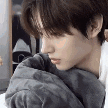a close up of a person 's face with a blanket around their shoulder .