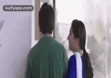 a man and a woman are standing next to each other looking at each other .