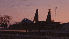a fighter jet is sitting on a runway at night