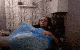 a man is holding a bag of popcorn in his lap