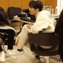 a man is sitting in a chair talking to another person