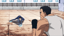 a man in a white tank top looks at a man doing a handstand