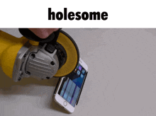 a phone is being grinded by a yellow grinder with the word holesome above it