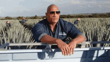 a man wearing sunglasses and a shirt that says ritz carl teredana leans against a railing