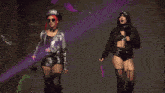 two women dancing in front of a nxt sign