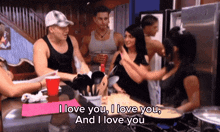 a group of people in a kitchen with a sign that says " i love you "