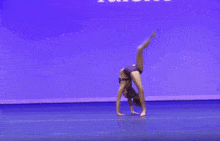 a young woman in a purple top and skirt is dancing on a blue background .
