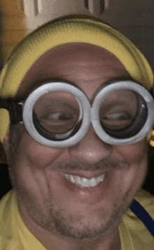 a man wearing a yellow hat and goggles is smiling for the camera