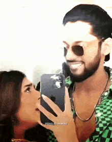 a man is taking a picture of a woman with his phone