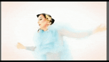 a woman in a blue and white dress with flowers in her hair is singing