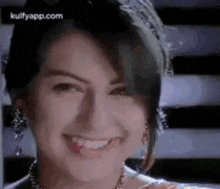 a close up of a woman 's face with a crown on her head smiling .