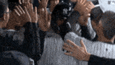 a new york yankees baseball player is surrounded by his teammates giving him a high five