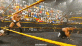 two men are wrestling in a wrestling ring with a referee watching .
