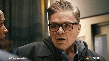 a man with glasses and a nbc logo on the bottom