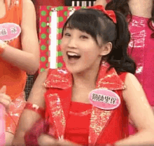 a woman wearing a red vest with a name tag that says ' ' ' ' on it