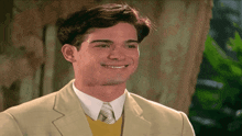a man in a suit and tie is smiling for the camera