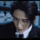 a close up of a man wearing glasses and a suit with chinese writing on his face