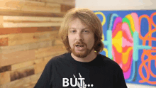 a man is wearing a black shirt that says but