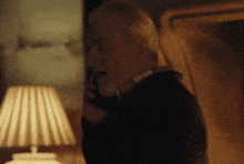 a man is talking on a phone in a dark room