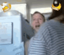 a man and a woman are standing in front of a refrigerator