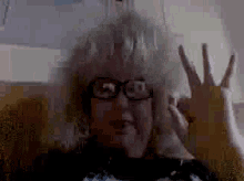 a pixelated image of a woman wearing glasses and making a peace sign