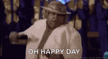 a man is holding a microphone and saying `` oh happy day '' .