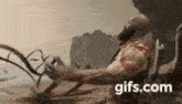 a man is laying on the ground with a gifs.com watermark on the bottom of the image .