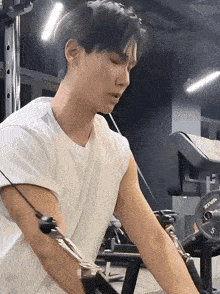 a man is using a machine in a gym to exercise his arm .