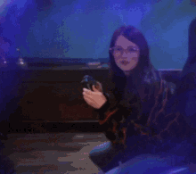 a woman wearing glasses is holding a phone in her hands