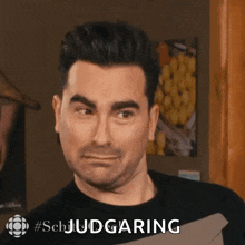 a man is making a funny face and the word judging is on the bottom right