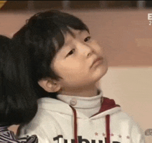 a little boy is sitting next to a girl and making a face .