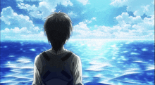 a man with a backpack is looking out over the ocean