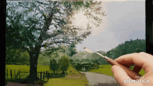 a person is holding a brush in front of a painting that says made in animonica