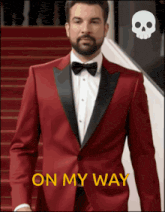 a man in a red tuxedo is walking down stairs with the words on my way above him
