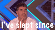 a man is sitting in front of a sign that says " i 've slept since "