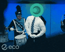 a man in a marching band has a green circle on his head with the word eco on the bottom