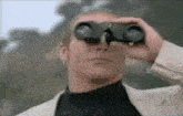 a man in a suit is looking through binoculars ..